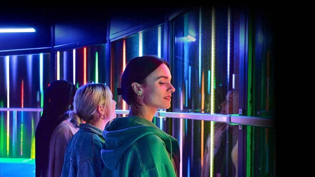 Visitors enjoying colorful lights at Euromast Lookout, Rotterdam.
