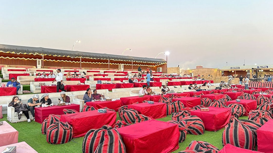 Desert camp seating area for evening safari with guests dining, Dubai.