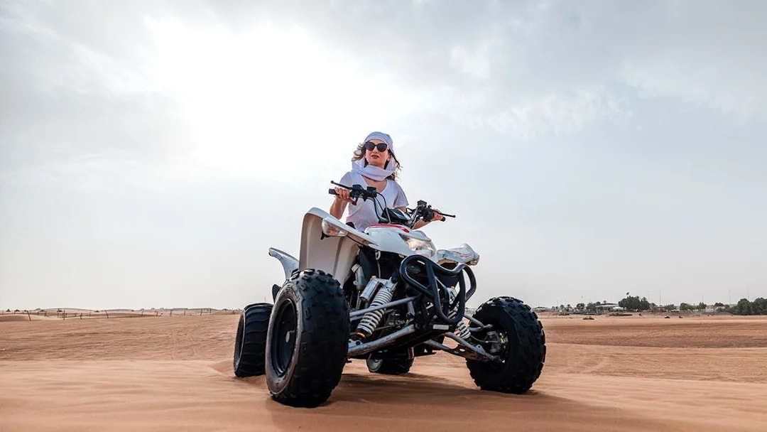Person riding an ATV on Dubai desert safari.