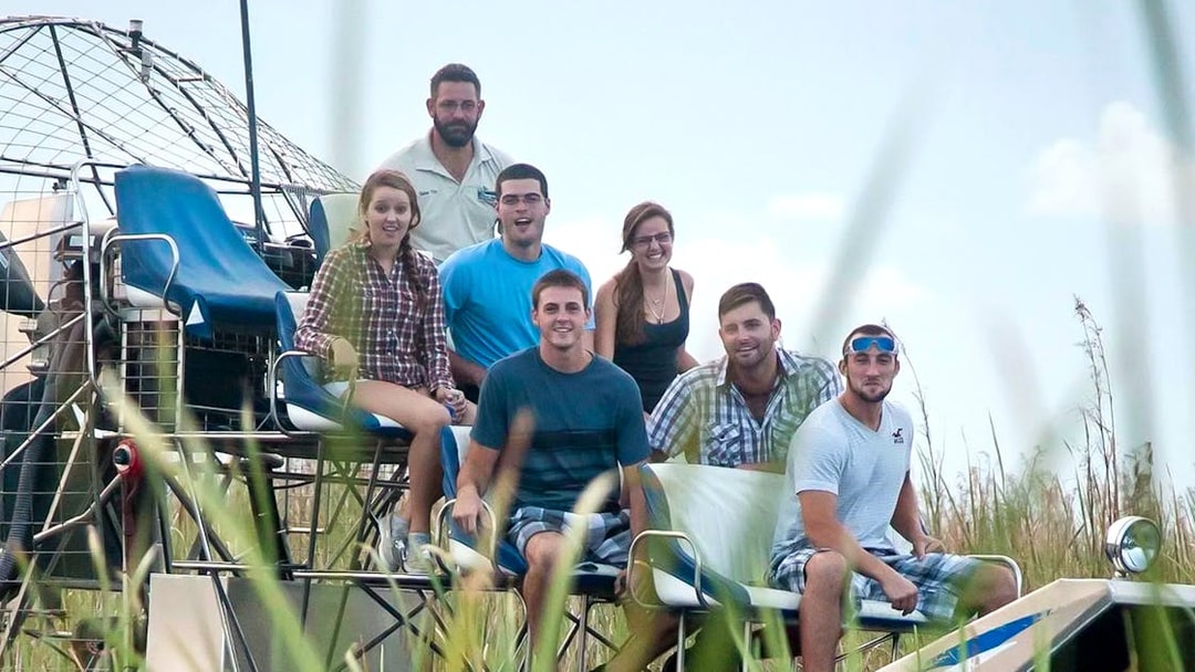 Group enjoying an Everglades airboat ride through marshland.