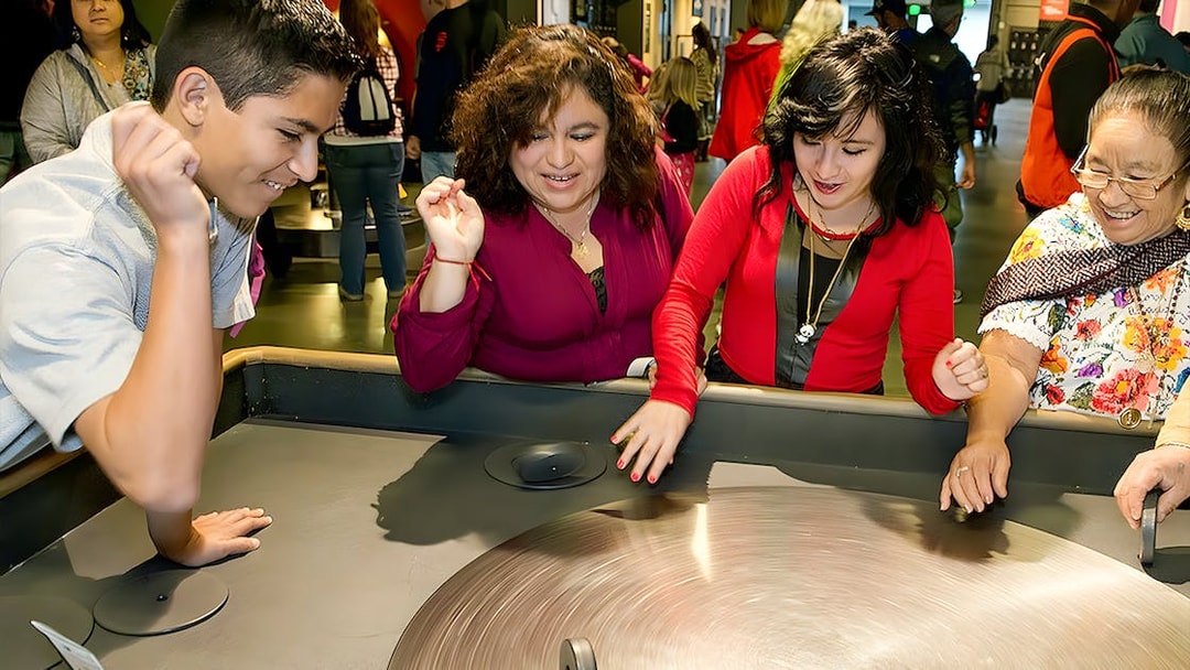 Visitors engaging with a spinning exhibit at the Exploratorium in San Francisco.