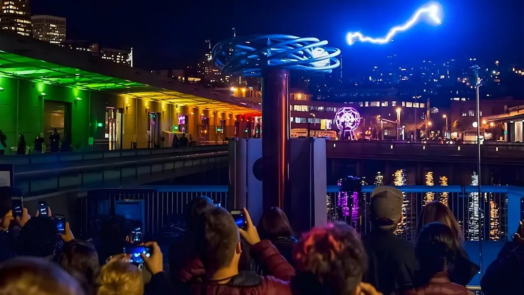 Crowd watching a light display at night outside the Exploratorium in San Francisco.