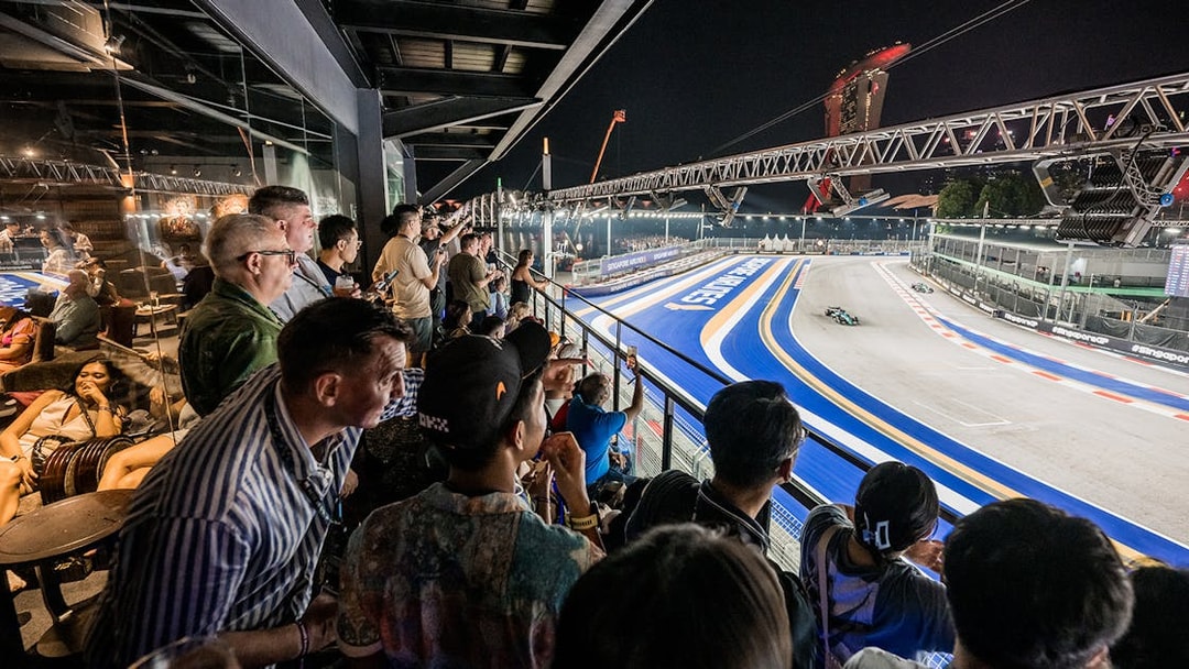 Spectators enjoying the Formula 1 Singapore Grand Prix 2025 from a hospitality suite overlooking the track.