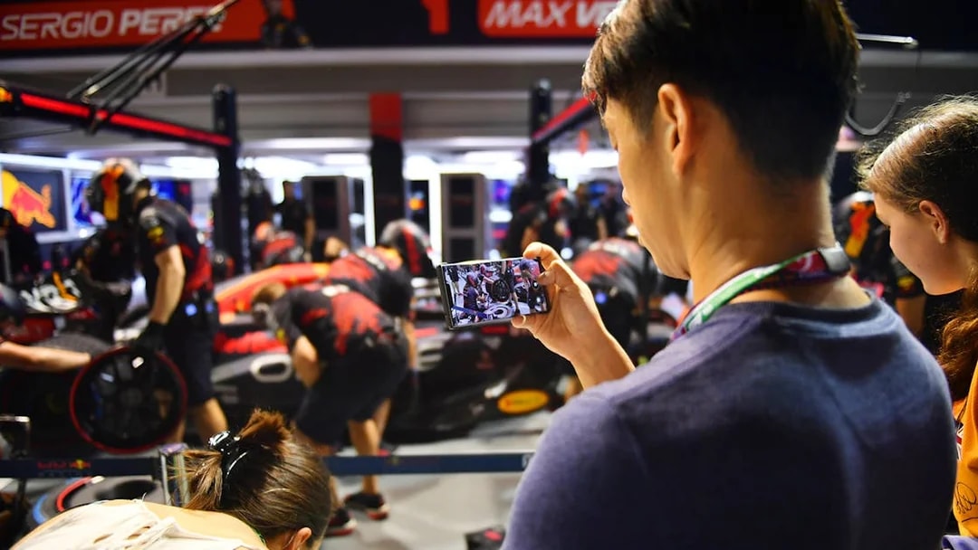 Pit crew working on a Formula 1 car during Singapore Grand Prix 2025, spectator capturing the moment.