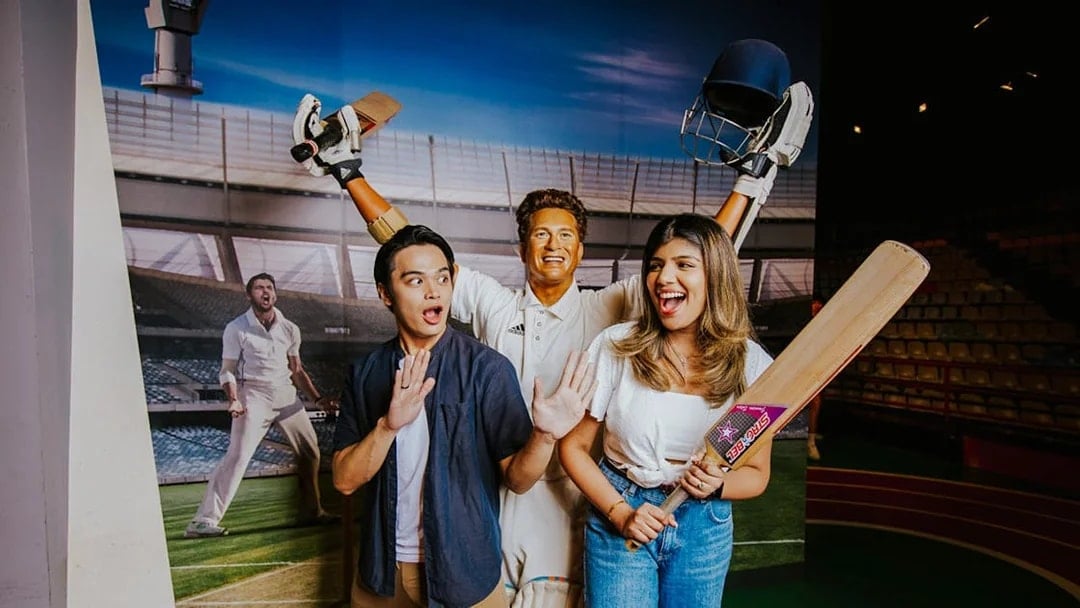 Sachin Tendulkar wax figure with visitors at Madame Tussauds Singapore.