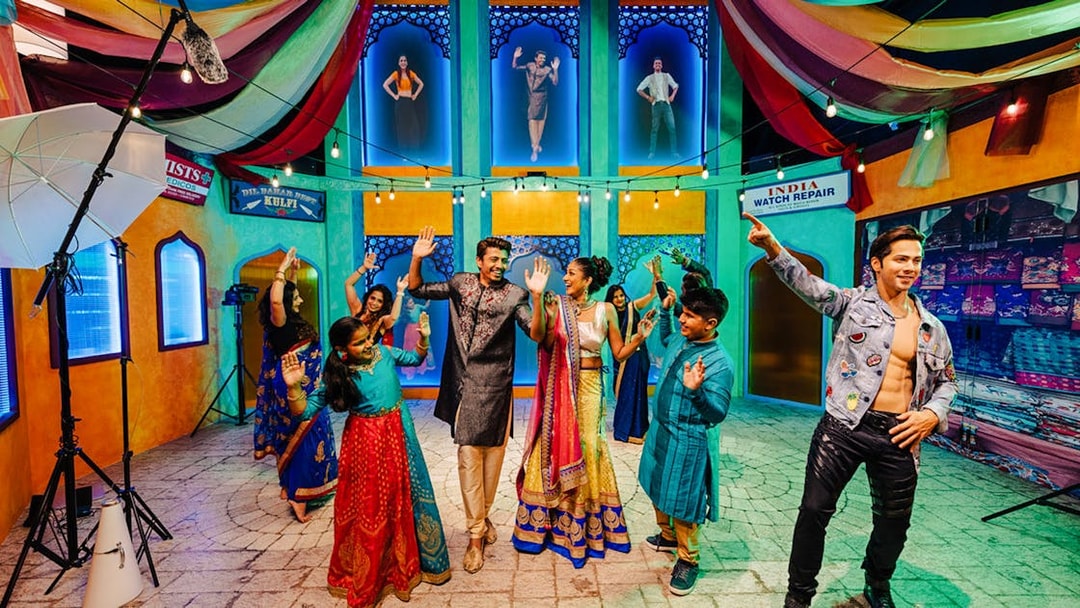 Varun Dhawan wax figure with visitors dancing at Madame Tussauds Singapore.