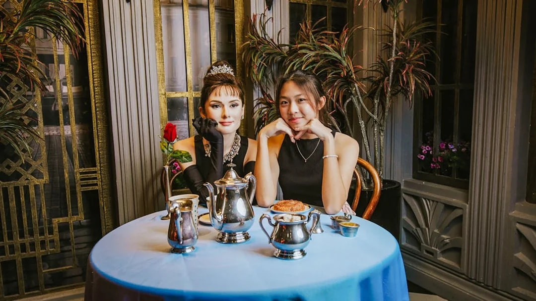 Woman posing with Audrey Hepburn wax figure at Madame Tussauds Singapore.