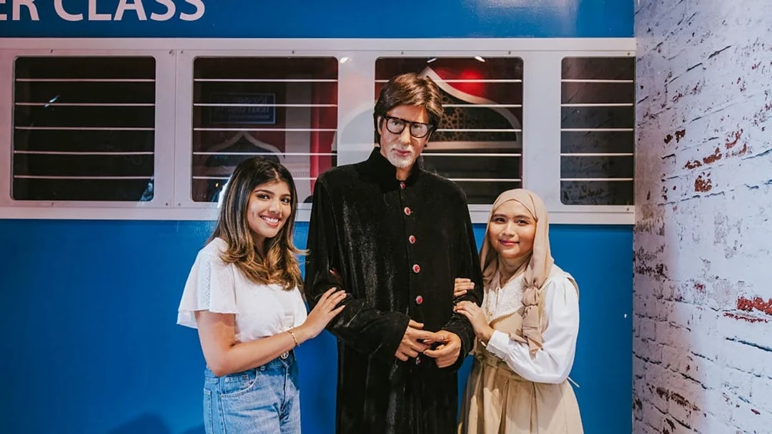 Wax figure of Amitabh Bachchan with visitors at Madame Tussauds Singapore