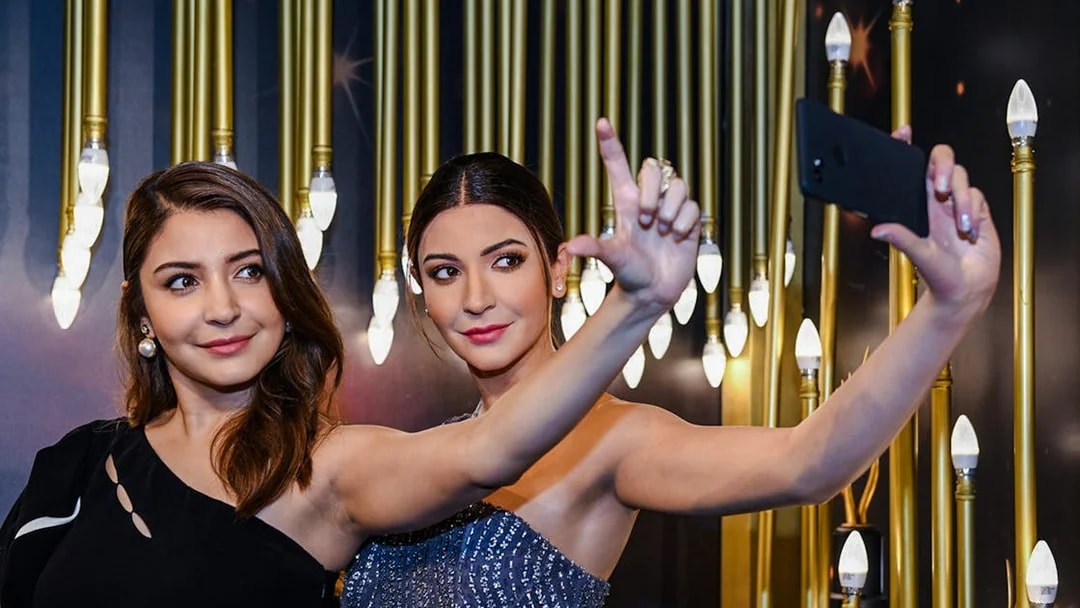 Bollywood actress taking a selfie with her wax figure at Madame Tussauds Singapore.