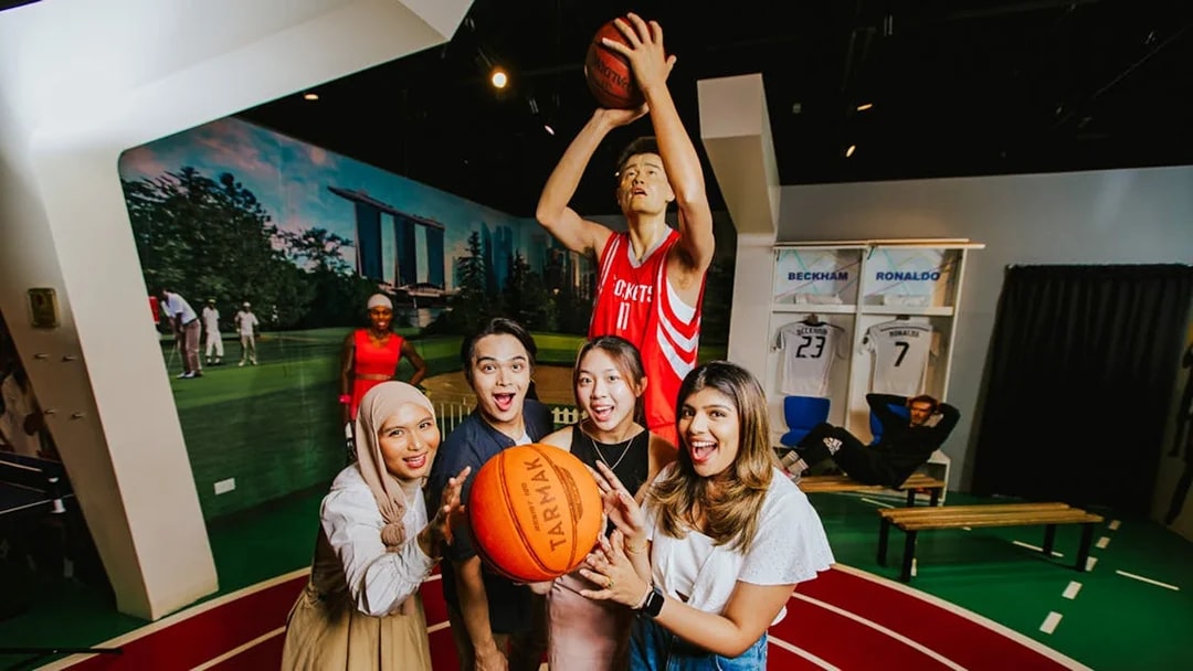 Visitors interacting with Yao Ming wax figure at Madame Tussauds Singapore.