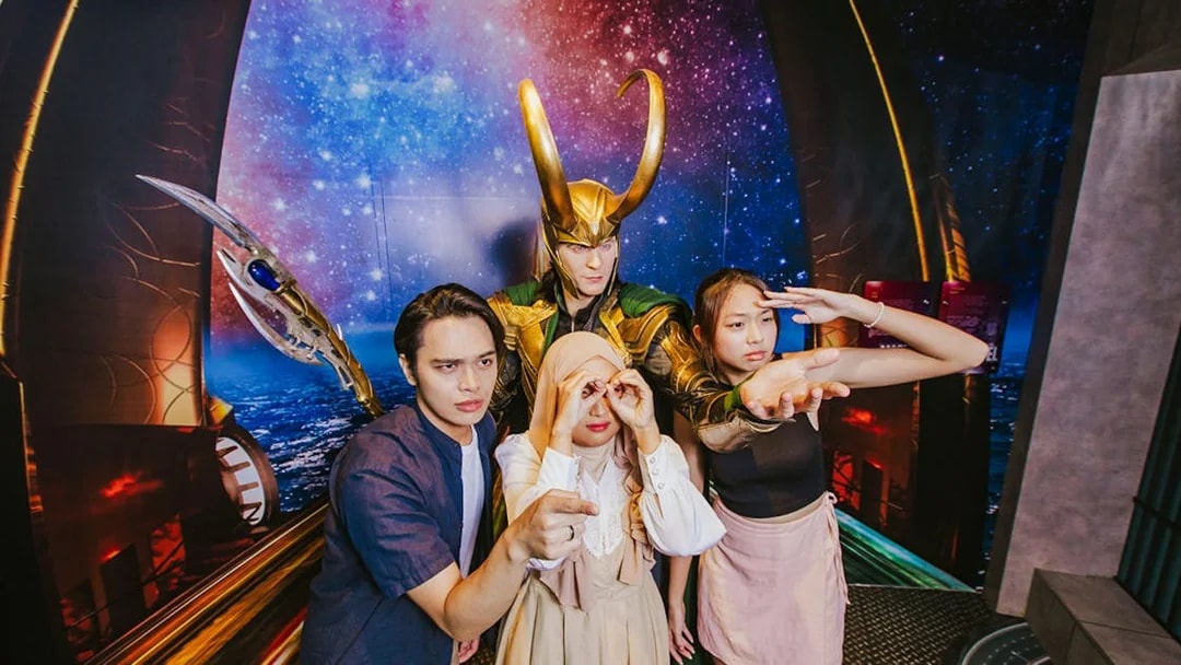 Visitors posing with Loki wax figure at Madame Tussauds Singapore.