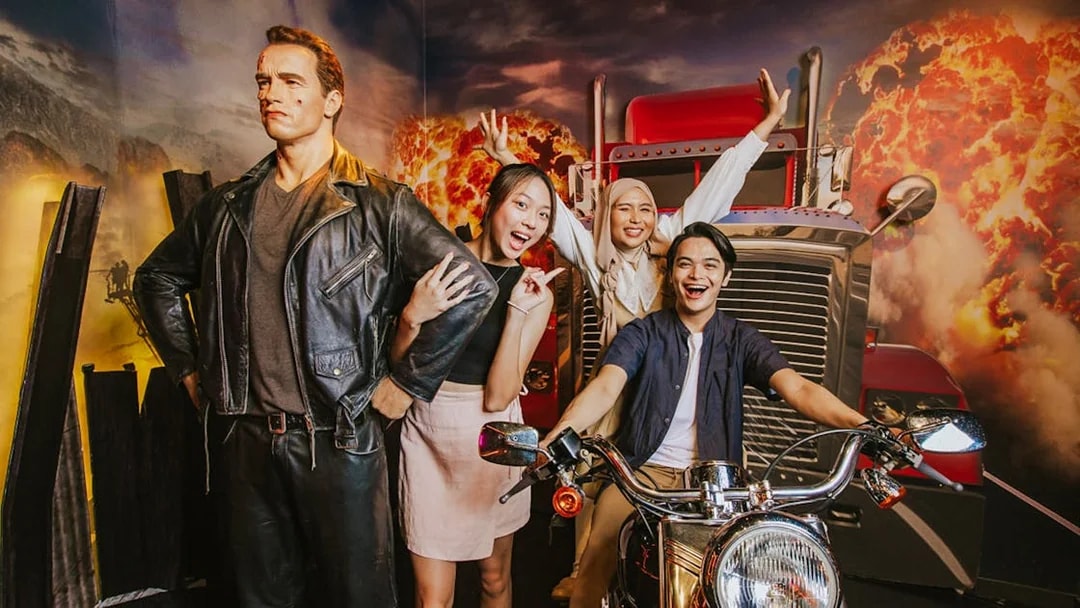 Wax figure of Terminator at Madame Tussauds Singapore with visitors posing nearby.