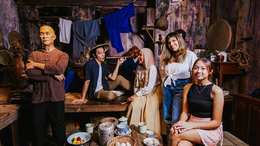 Wax figures and visitors in a historical Singaporean setting at Madame Tussauds Singapore.