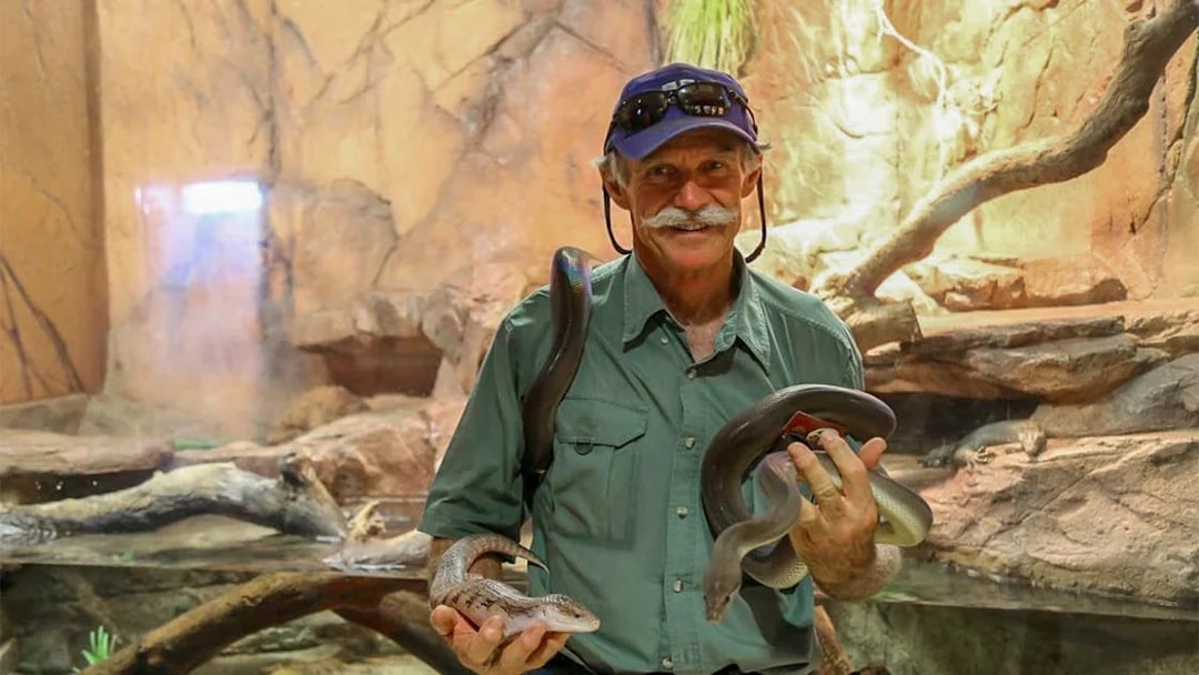 Man holding snakes at Crocosaurus Cove, Darwin, Australia.