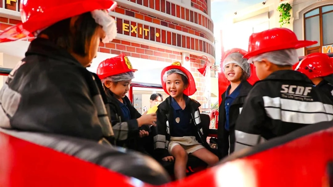 Children in firefighter uniforms at KidZania playing a fire rescue role.