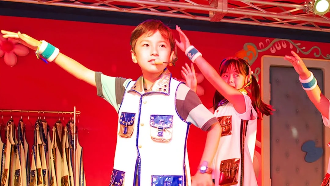 Children performing on stage at KidZania Singapore school program.