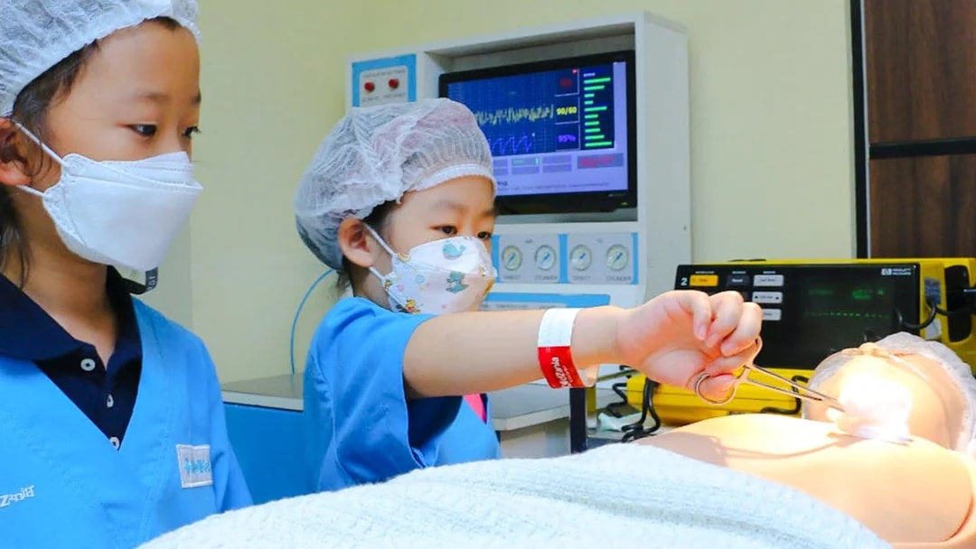 Children practicing surgery at KidZania with medical equipment.