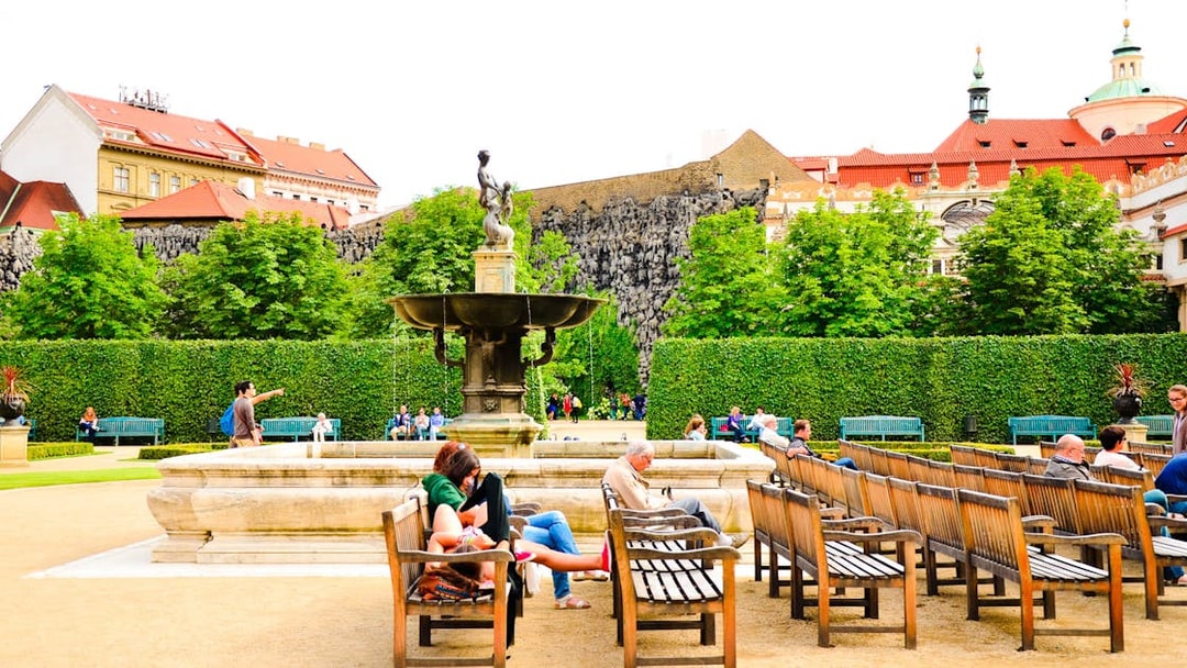 Visitors relaxing by a fountain in the gardens of Prague Castle.