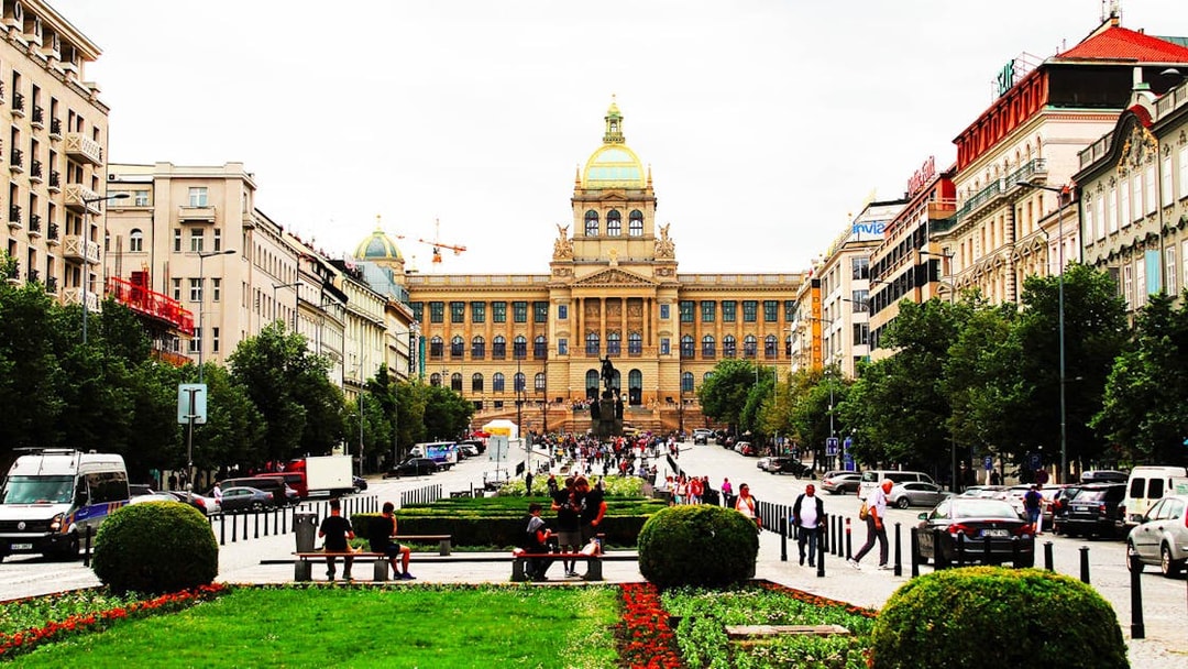Prague National Museum with bustling street and visitors in front.