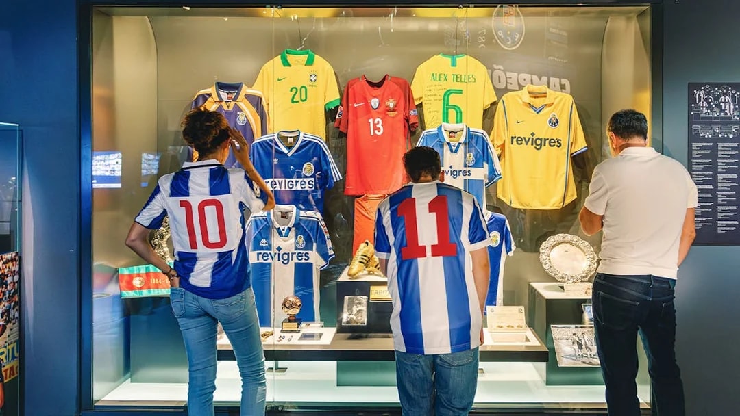 Visitors at FC Porto stadium museum viewing historic jerseys display.