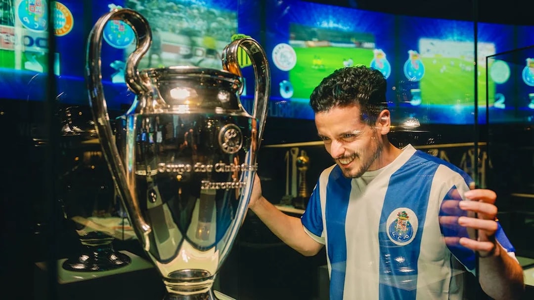 Visitor admiring trophy at FC Porto stadium museum.