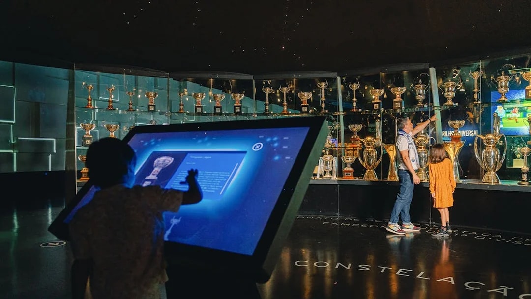 Visitors exploring FC Porto stadium museum trophy display.