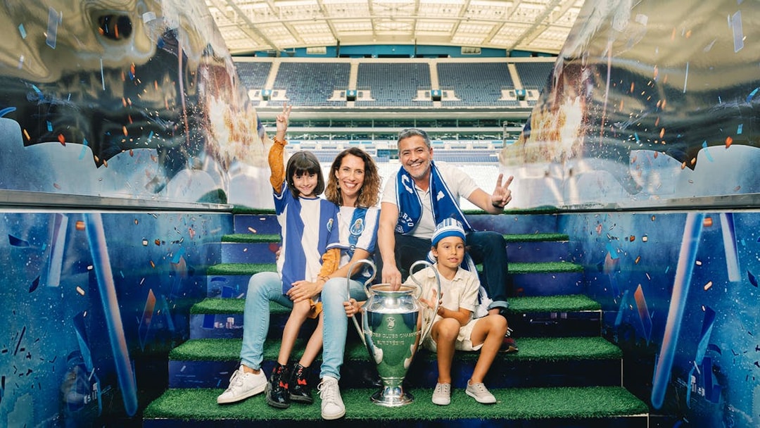 Visitors posing with a trophy at FC Porto stadium museum.
