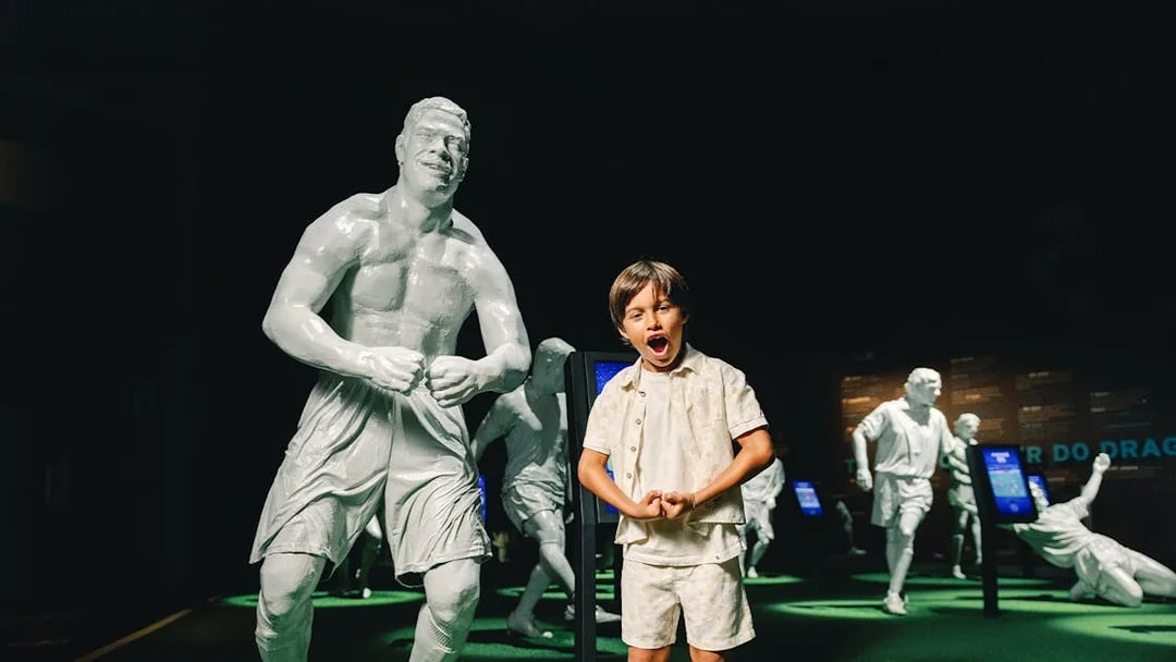 Visitors at FC Porto stadium museum with football legends statues.