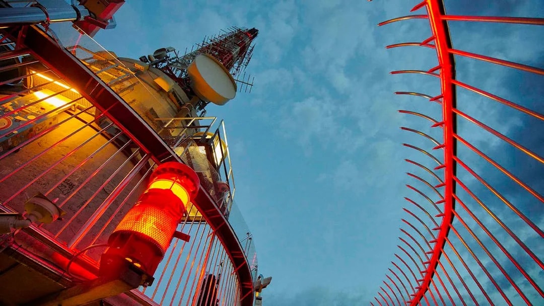 Fernsehturm Stuttgart observation deck with red lights against evening sky.