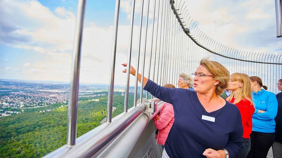 Visitors on the observation deck of Fernsehturm Stuttgart, overlooking the cityscape.