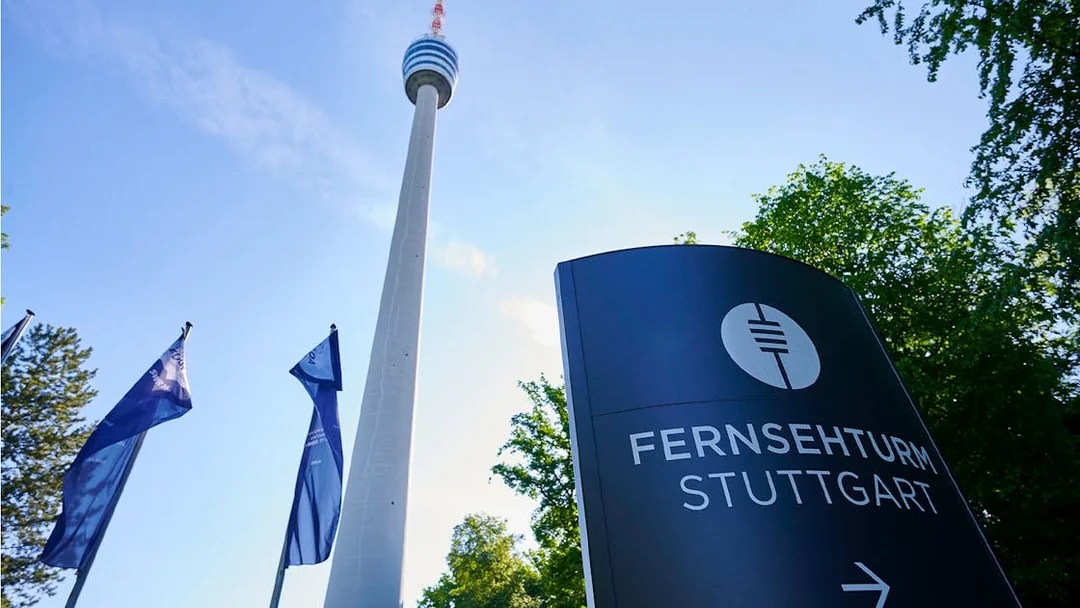 Fernsehturm Stuttgart tower with entry sign and flags in foreground.