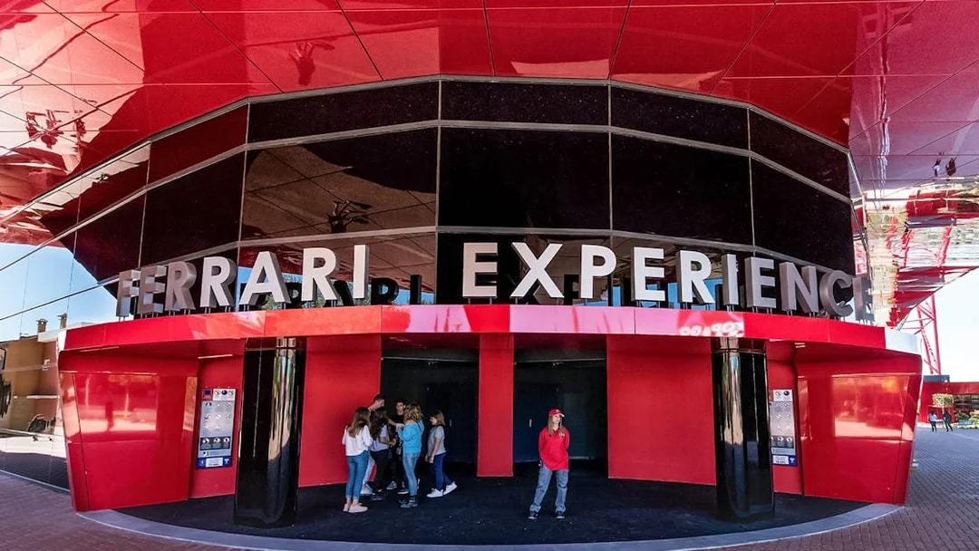 Ferrari Land entrance with visitors at the Ferrari Experience building.