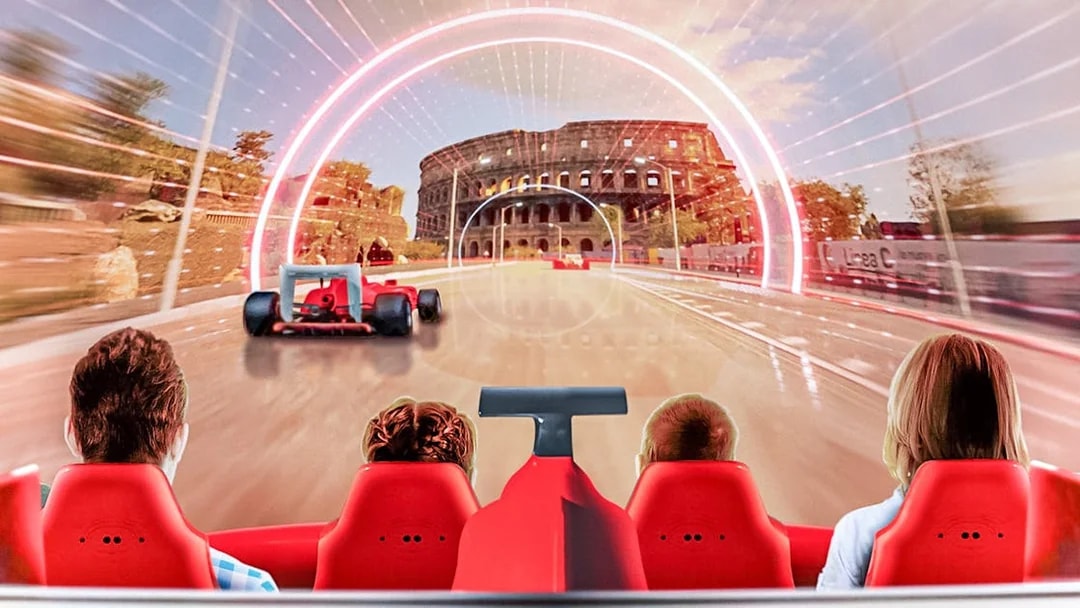 Tourists on a ride at Ferrari Land with a view of a racetrack and Colosseum backdrop.