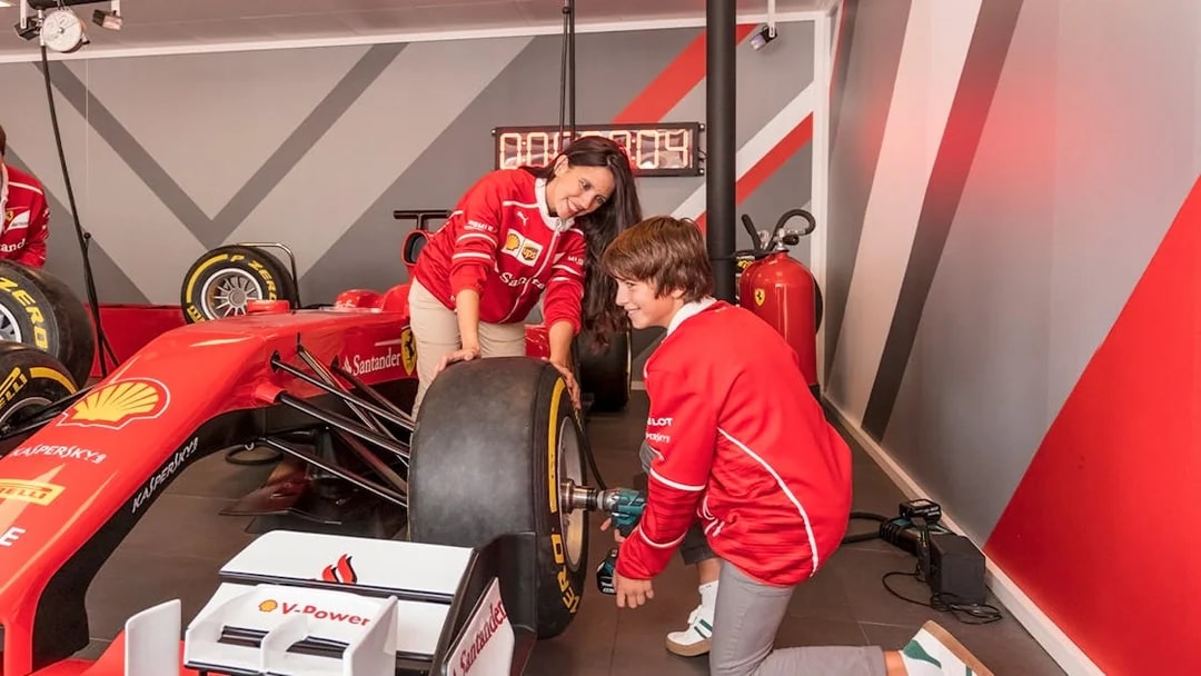 Visitors changing a tire on a Formula 1 car at Ferrari Land.