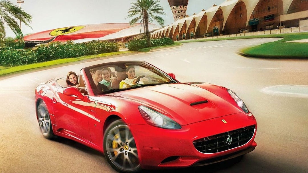 Visitors driving a red Ferrari at Ferrari World Abu Dhabi.