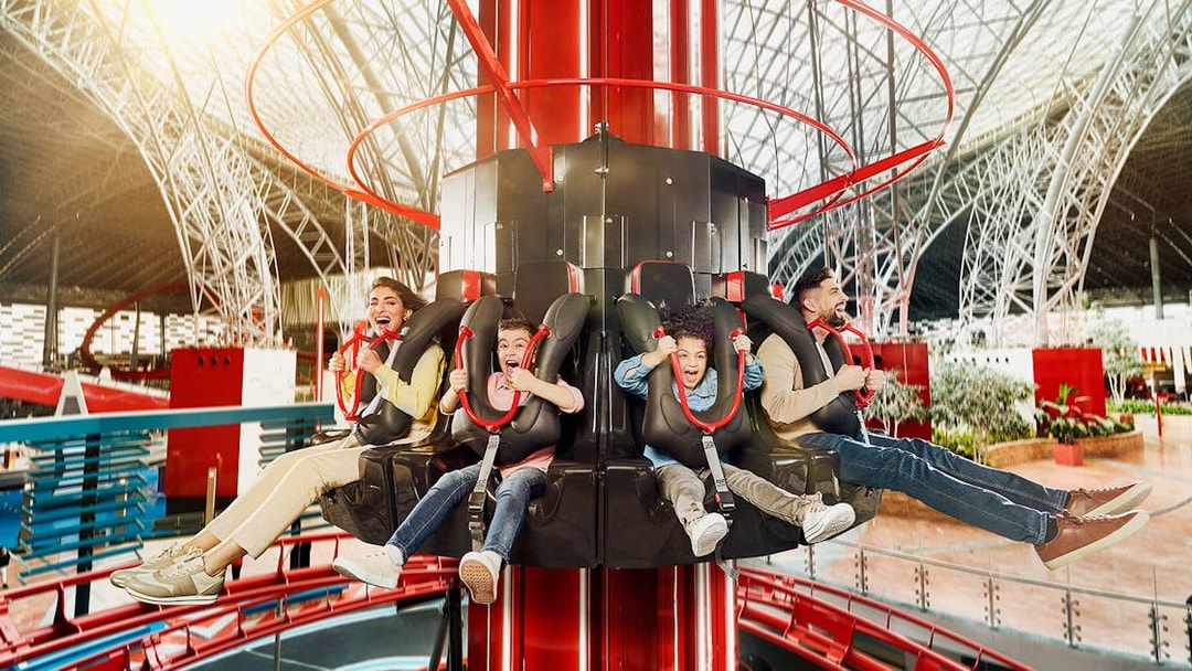 People enjoying a thrilling ride at an indoor amusement park on the Corniche.