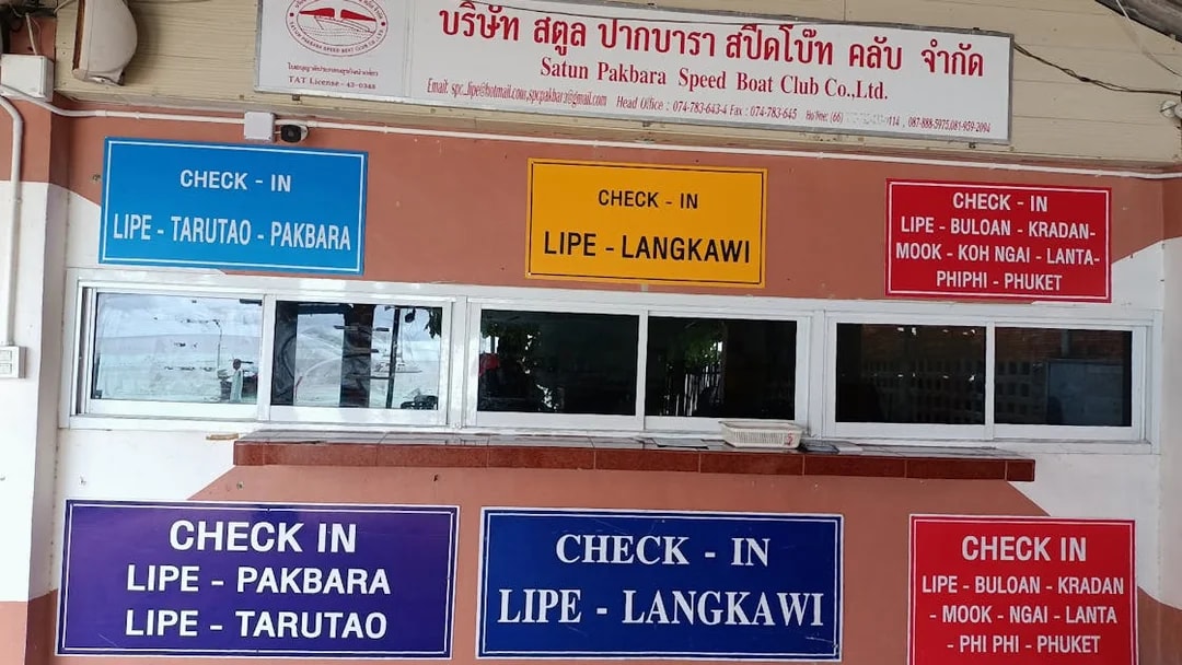 Check-in signs for ferry routes between Koh Lipe, Langkawi, and other destinations.