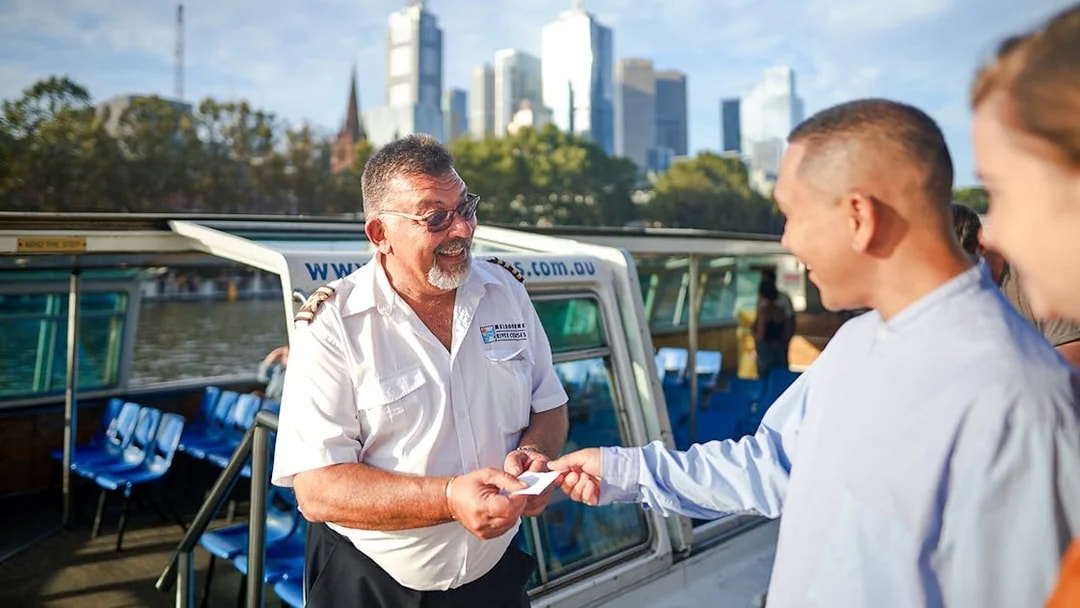 Cruise captain checking tickets of guests on Yarra River sightseeing cruise.