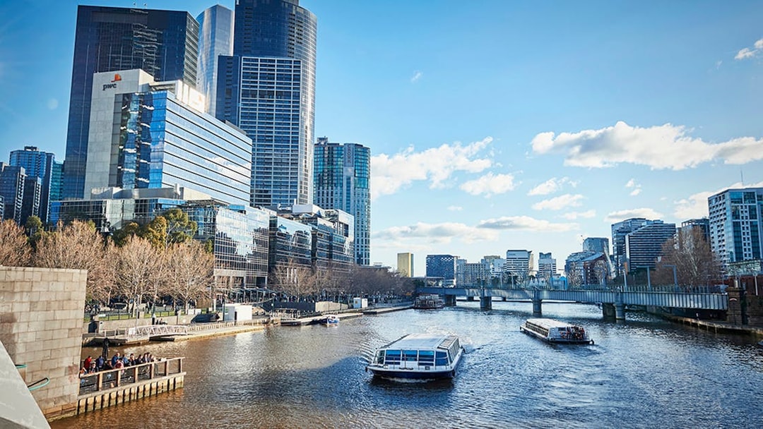 Ferry cruising on Yarra River with Melbourne city skyline in the background.