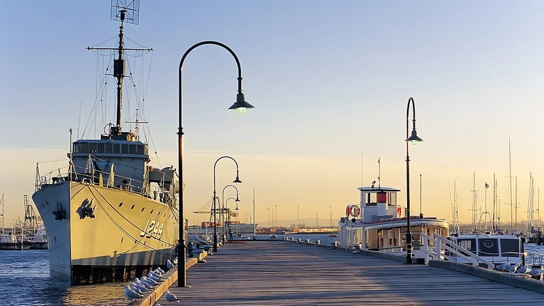 Historic ship docked at Gem Pier, Williamstown, with seagulls along the pier at sunset.