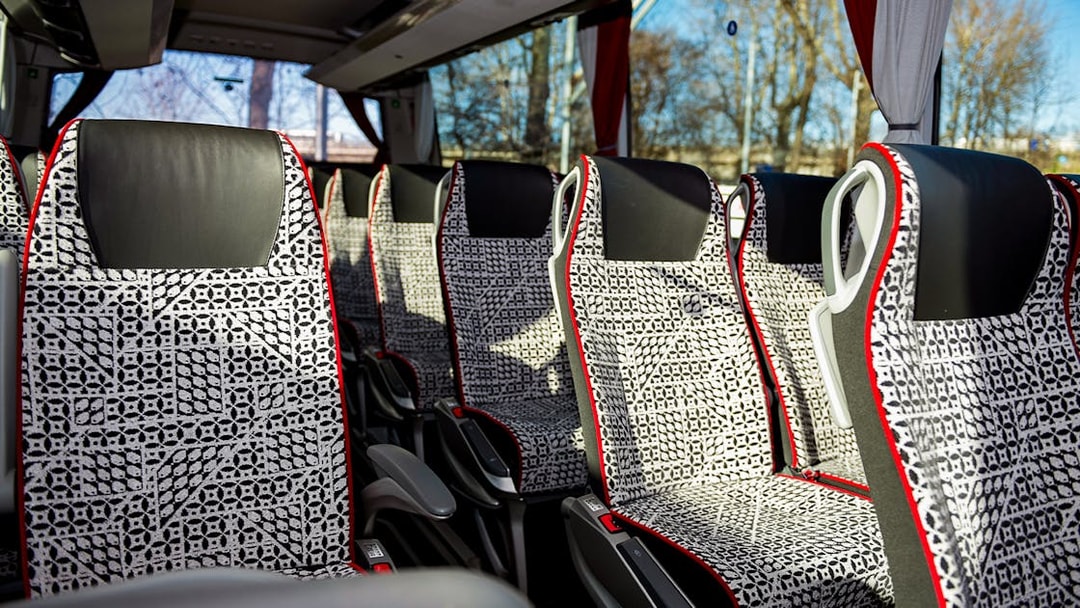 SIT Bus Shuttle seats with patterned upholstery and armrests.