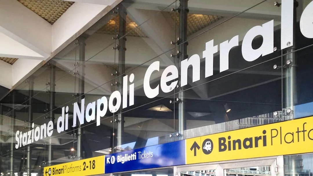 Naples Central Station entrance signage for train platforms and ticketing.
