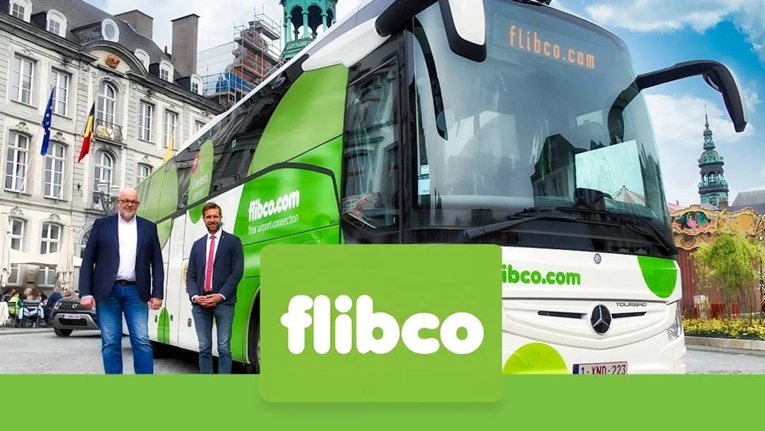 Flibco shuttle bus parked in front of a historic building, offering transport from Frankfurt Hahn Airport to Frankfurt City.