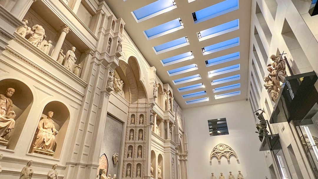 Interior view of Florence Duomo Museum with sculptures and architectural details.