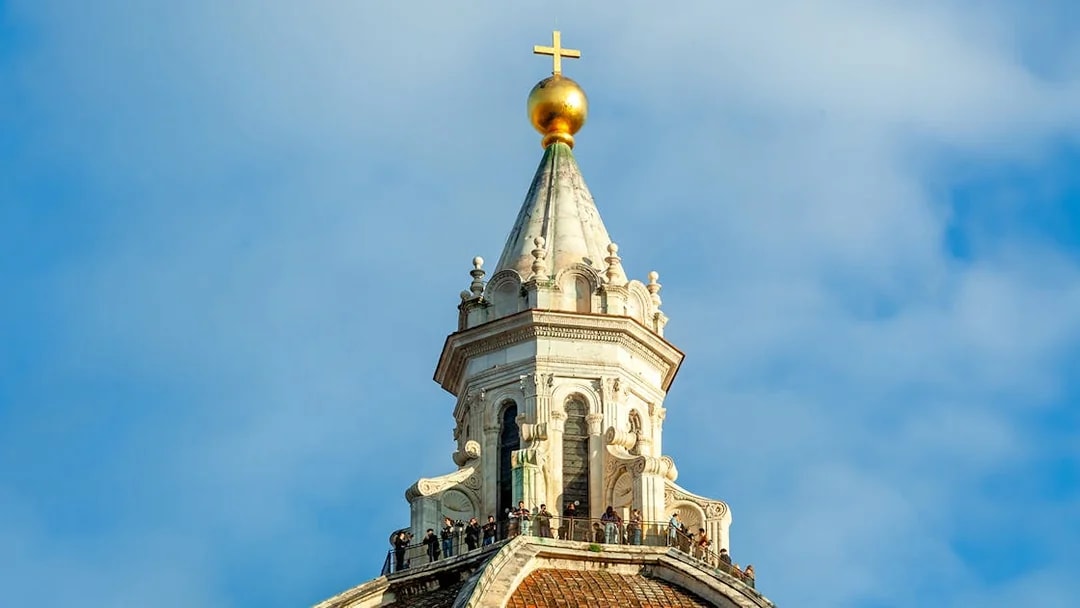 Dome details of Florence Cathedral with cross and observation deck.