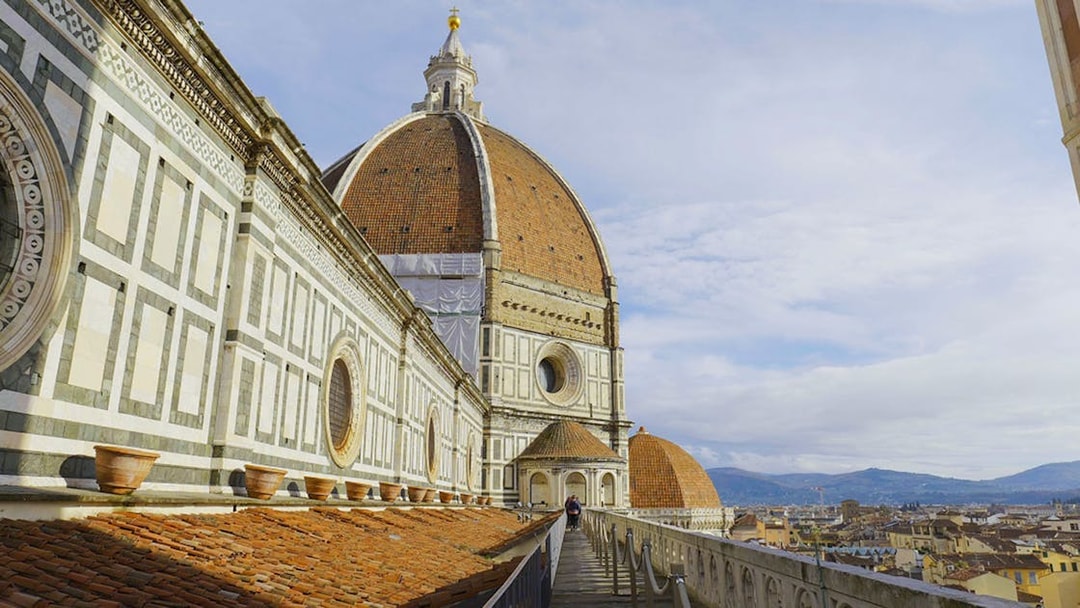 Terrace view of Florence Cathedral with dome and cityscape in the background.