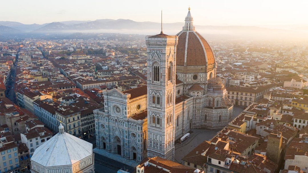 Florence Duomo aerial view with surrounding cityscape at sunrise.