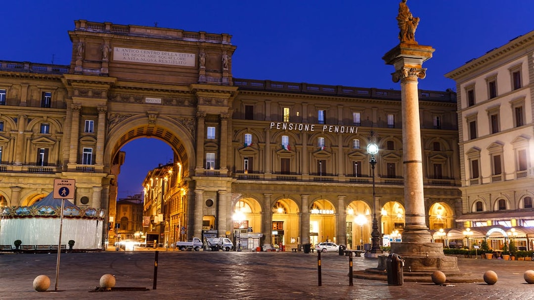 Republic Square in Florence at night with illuminated arch and column.