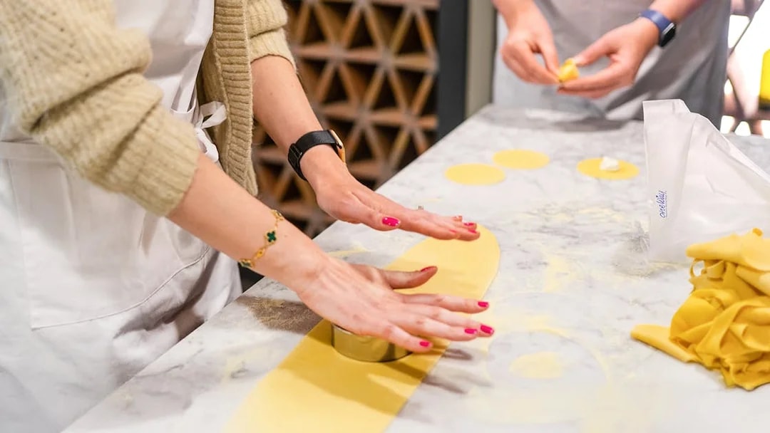 Hands rolling pasta dough in a Florence pasta-making class.