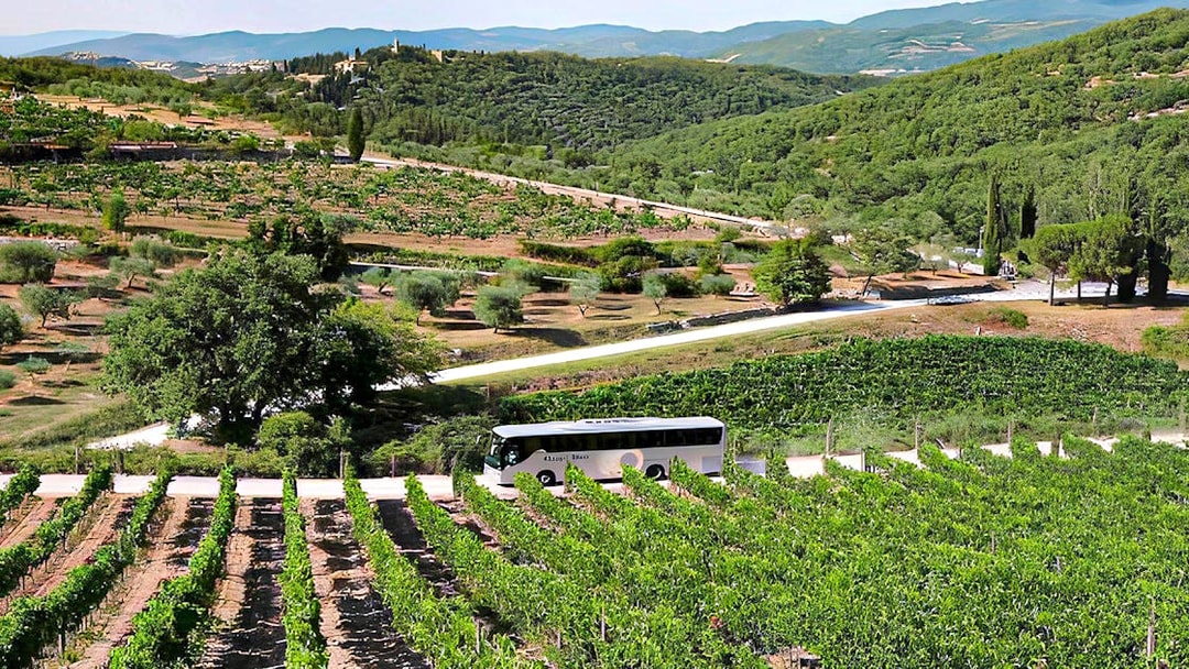 Bus traveling through Chianti vineyards during Florence wine tour.